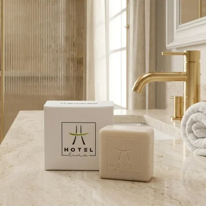 Linea cortesia per hotel sapone in scatola da 25g esposto su un piano in marmo in un bagno di lusso con dettagli oro.