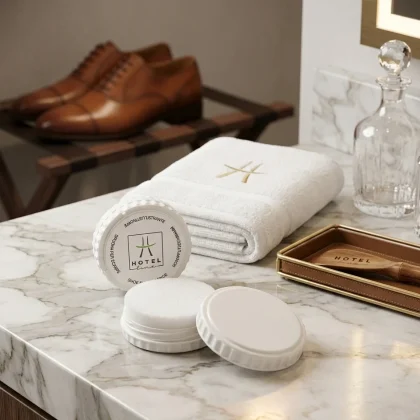 Spugna lustrascarpe per hotel in astuccio bianco con logo Hotel Line, aperta su un piano di marmo accanto a scarpe classiche da uomo in pelle.