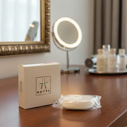 Set cortesia vanity kit per hotel: confezione igienica con dischetti struccanti e cotton fioc della linea Hotel Line, presentati in un ambiente bagno elegante con specchio cosmetico e arredi di classe