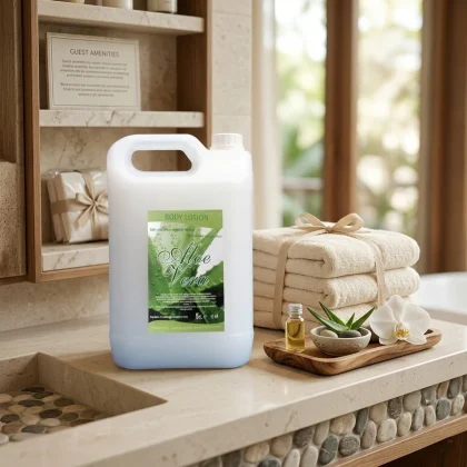 Tanica da 5 litri di crema corpo hotel all'Aloe Vera su un piano in pietra con asciugamani, fiori di orchidea e foglie di aloe fresca.