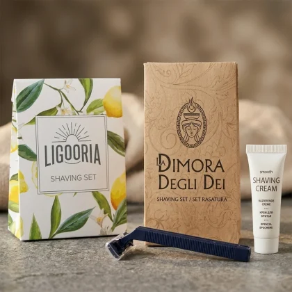 Due modelli di set rasatura hotel in sacchetto di carta: versione botanica Ligooria e versione kraft La Dimora degli Dei con rasoio blu notte e crema Smooth.